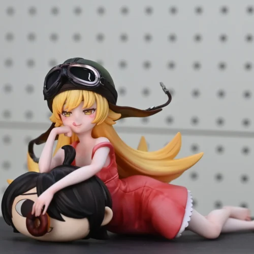 "Exclusive 1/6 scale Oshino Shinobu Monogatari resin statue. Playful Shinobu in pink, seated with helmet and iconic Rubbish-kun plush."