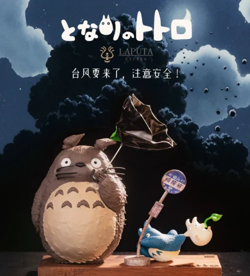 "Artistic Totoro: Wind Advisory resin statue captures whimsical Totoro characters in a dynamic wind-swept scene on an elegant wood base."