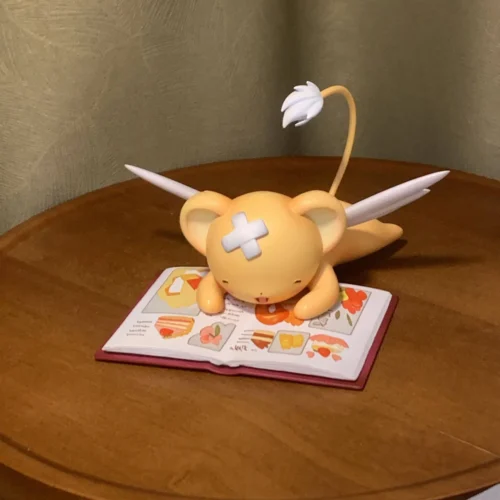 "Handcrafted, limited edition Kero-chan Reading Cardcaptor Sakura statue by Kulokefu Studio. Intricate Kero-chan details on stacked books."