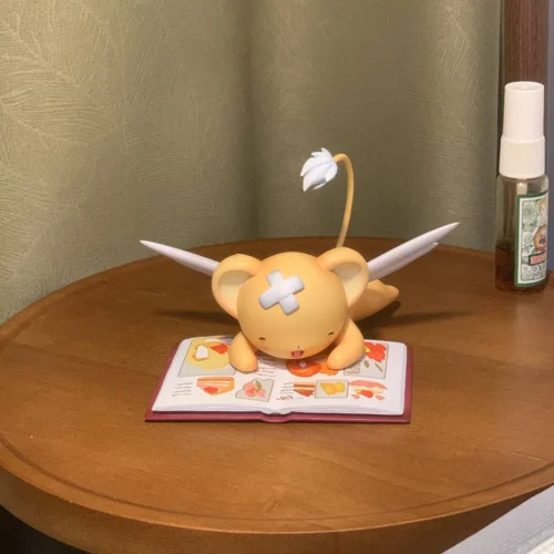 "Captivating limited edition Kero-chan figure, handcrafted by Kulokefu Studio, whimsically reading on stacked books, a premium Cardcaptor Sakura colle."