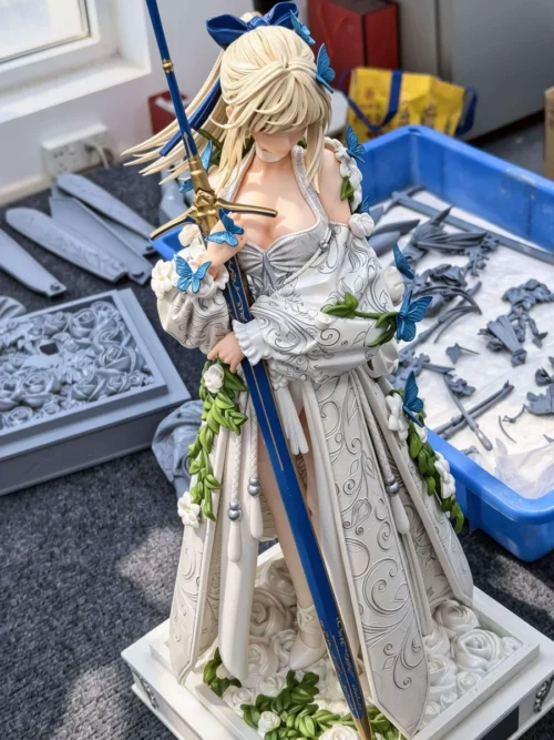 "Exquisite 1/4 Artoria Lily Wedding Gown Fate statue. Gallery details: pure white dress, intricate floral base, dynamic pose, ethereal blue butterflies."