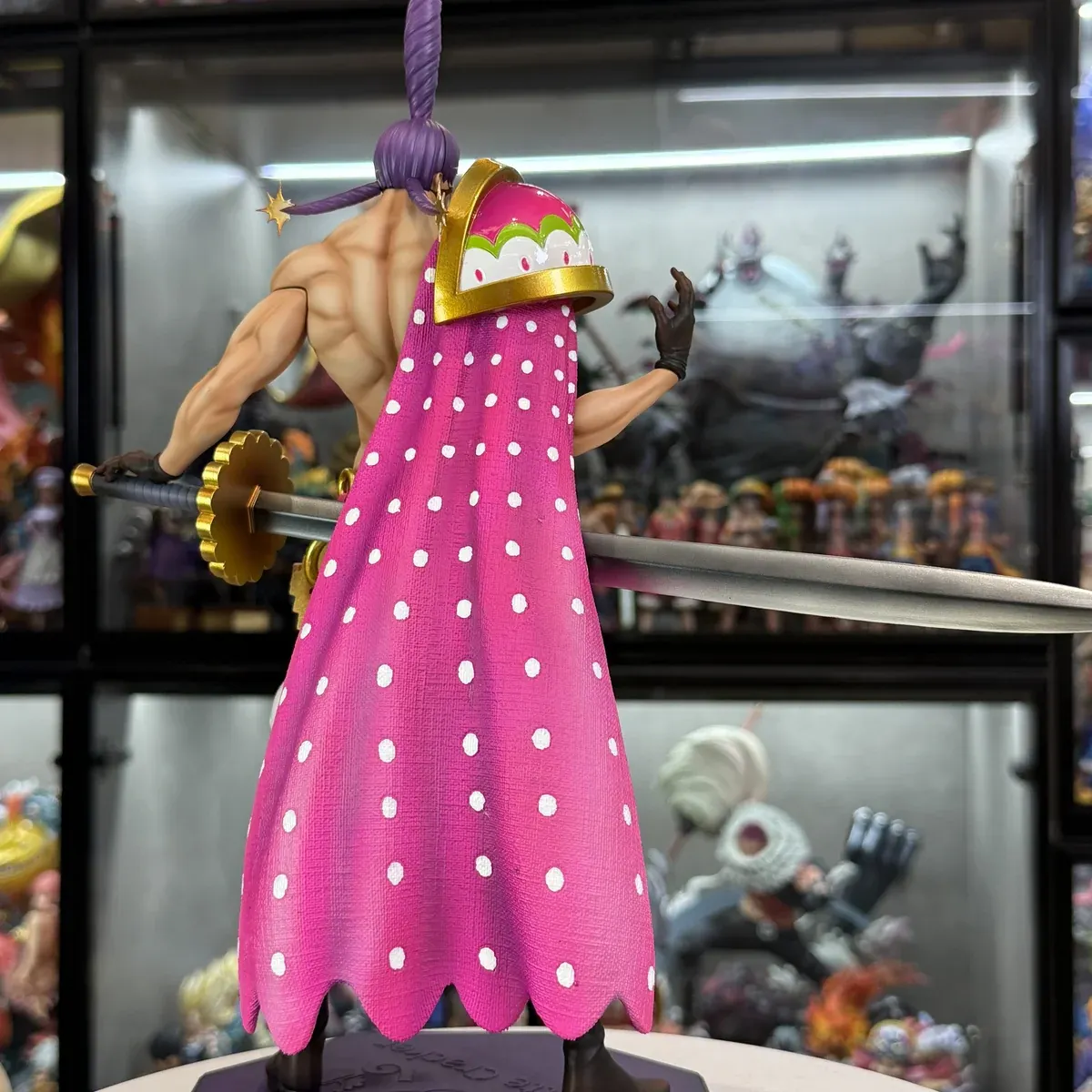 Rear view of the Charlotte Cracker figure shows his pink polka-dot cape, muscular sculpt, and giant sword above a limited 38-unit biscuit base.